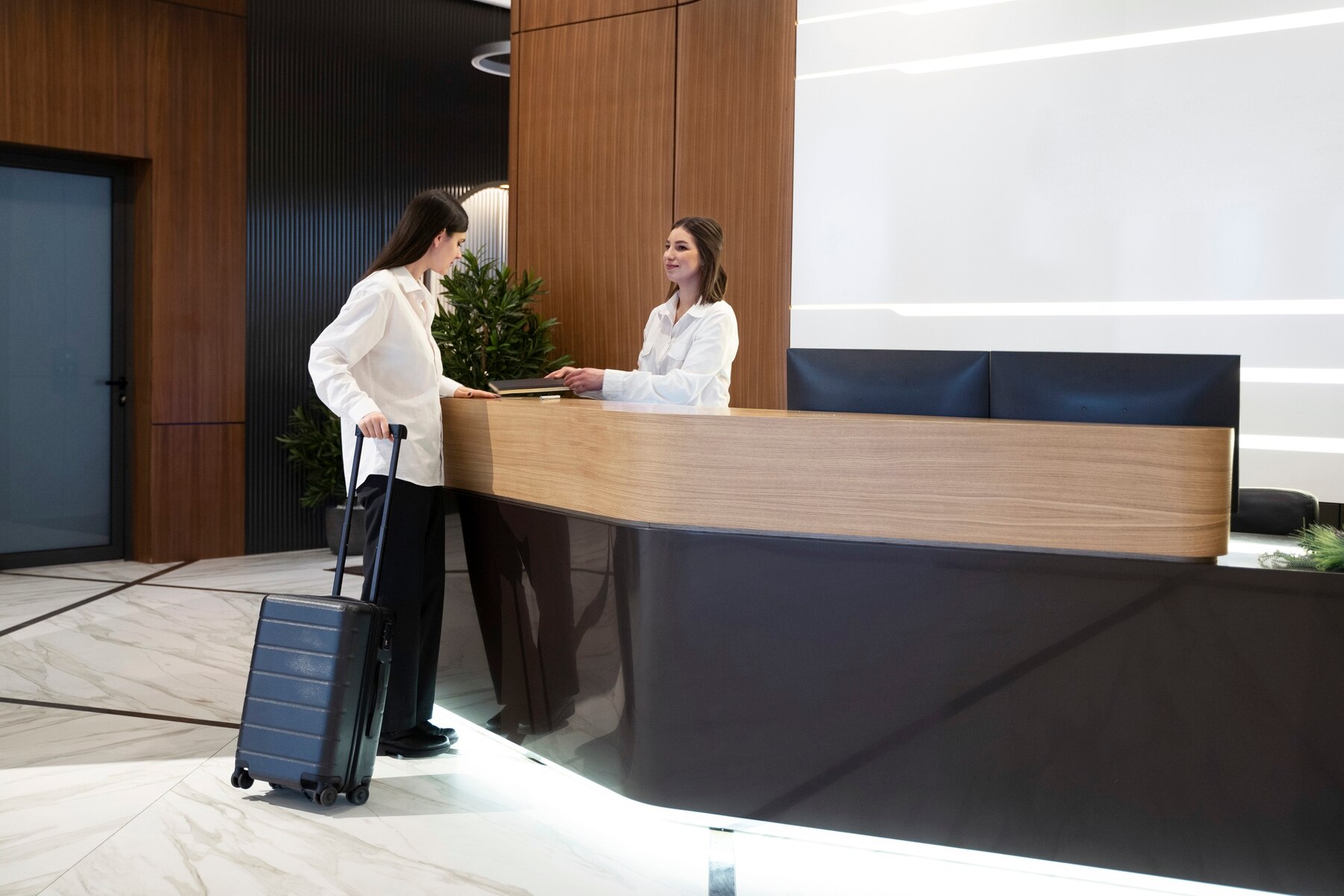 woman-talking-with-hotel-receptionist-lobby_23-2149304051